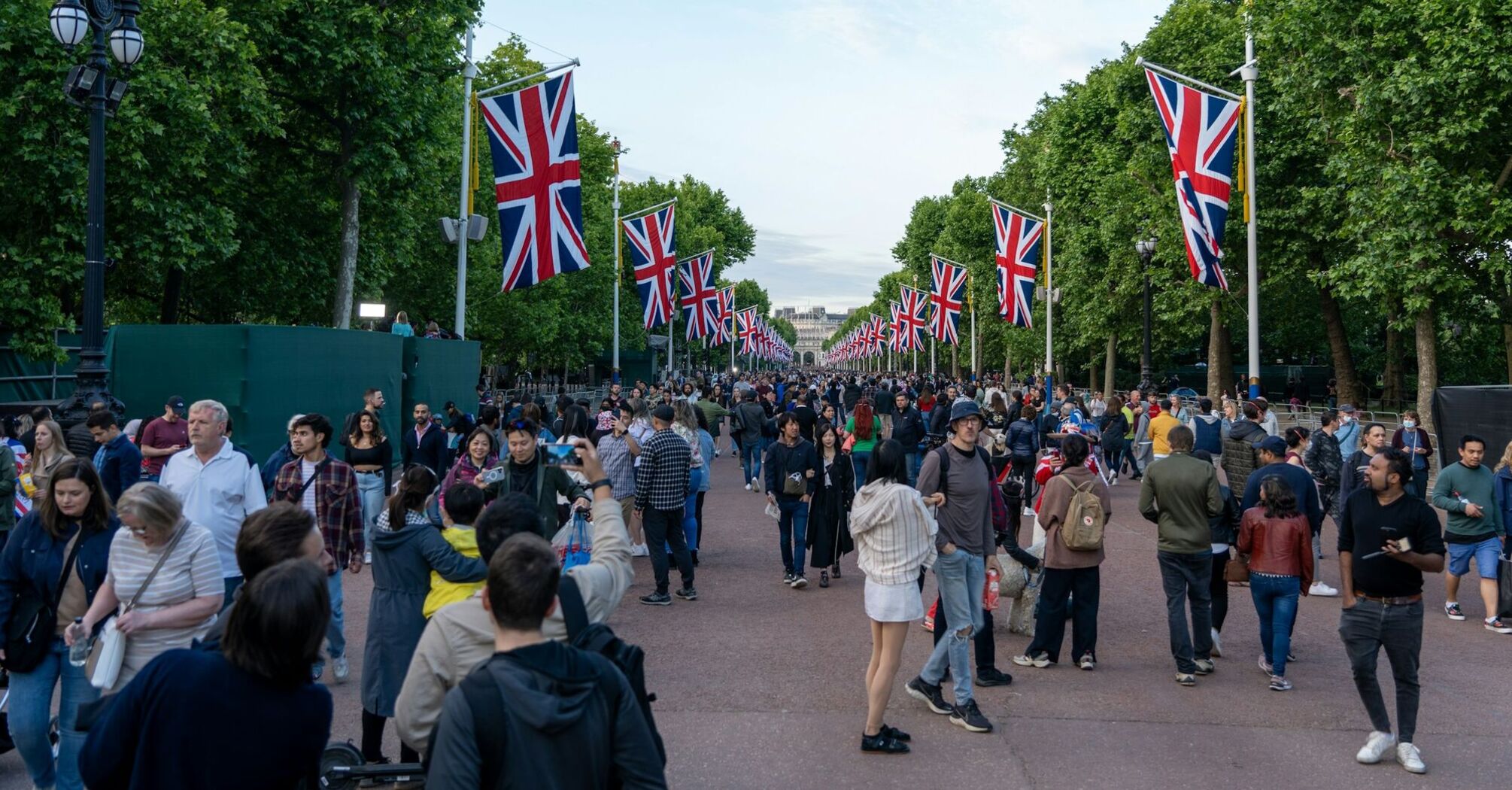 Crowd walking along a street lined with Union Jack flags in Britain