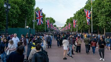 Crowd walking along a street lined with Union Jack flags in Britain
