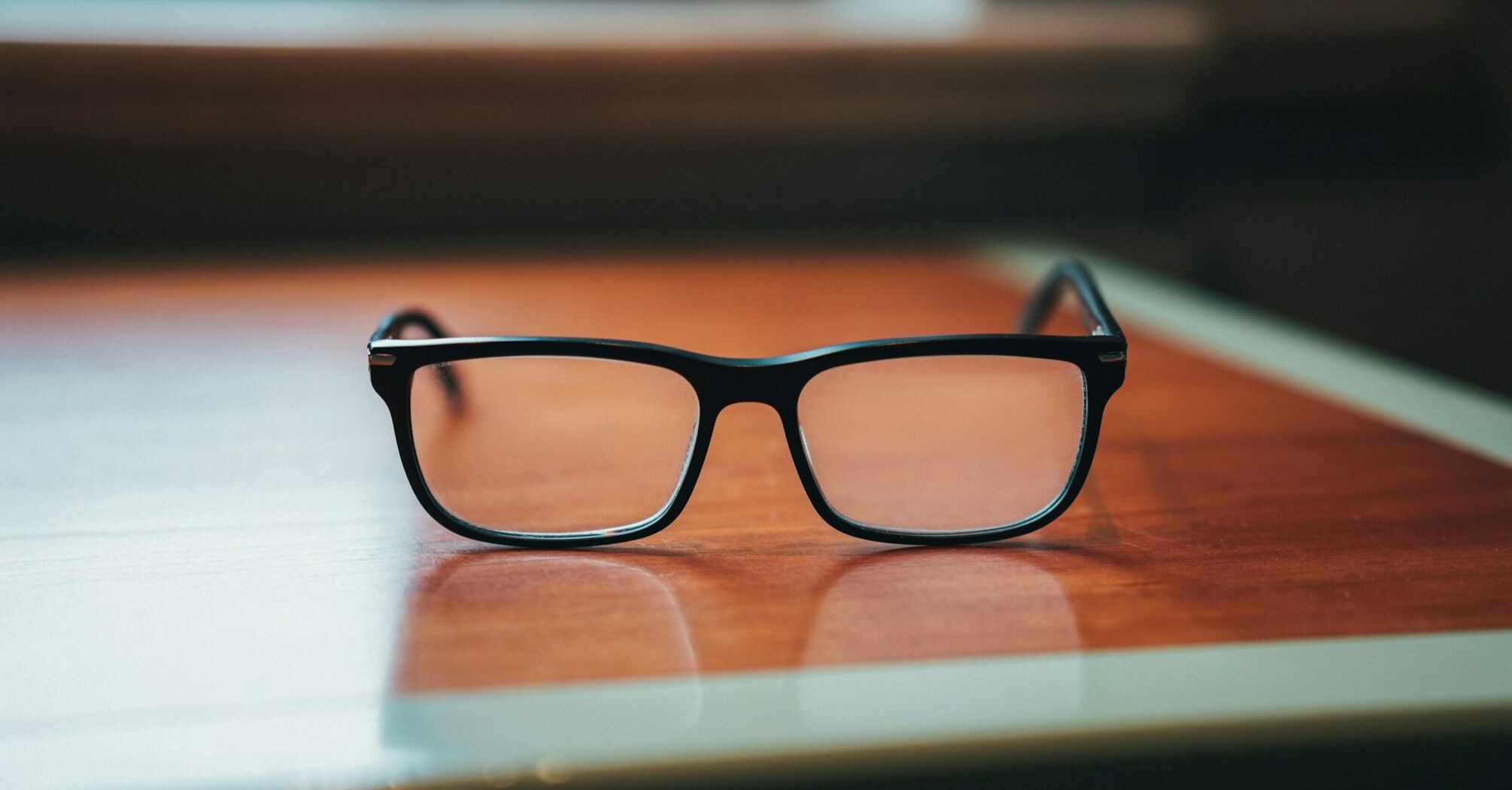 Black glasses on a wooden table