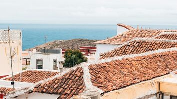 Terracotta-roofed houses in Canary Islands overlooking the ocean on a bright day