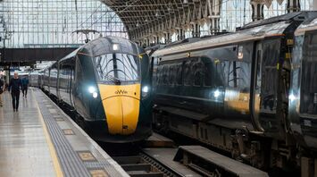 A GWR train at a station platform under an arched glass roof, preparing for departure