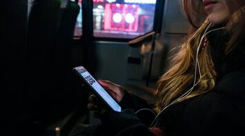 A person using a phone on a bus at night