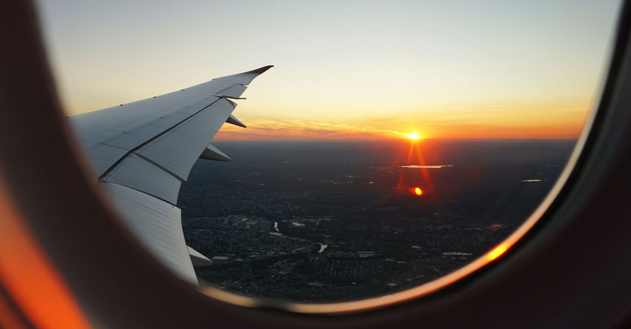 View of airplane wing and sunset from the window during flight