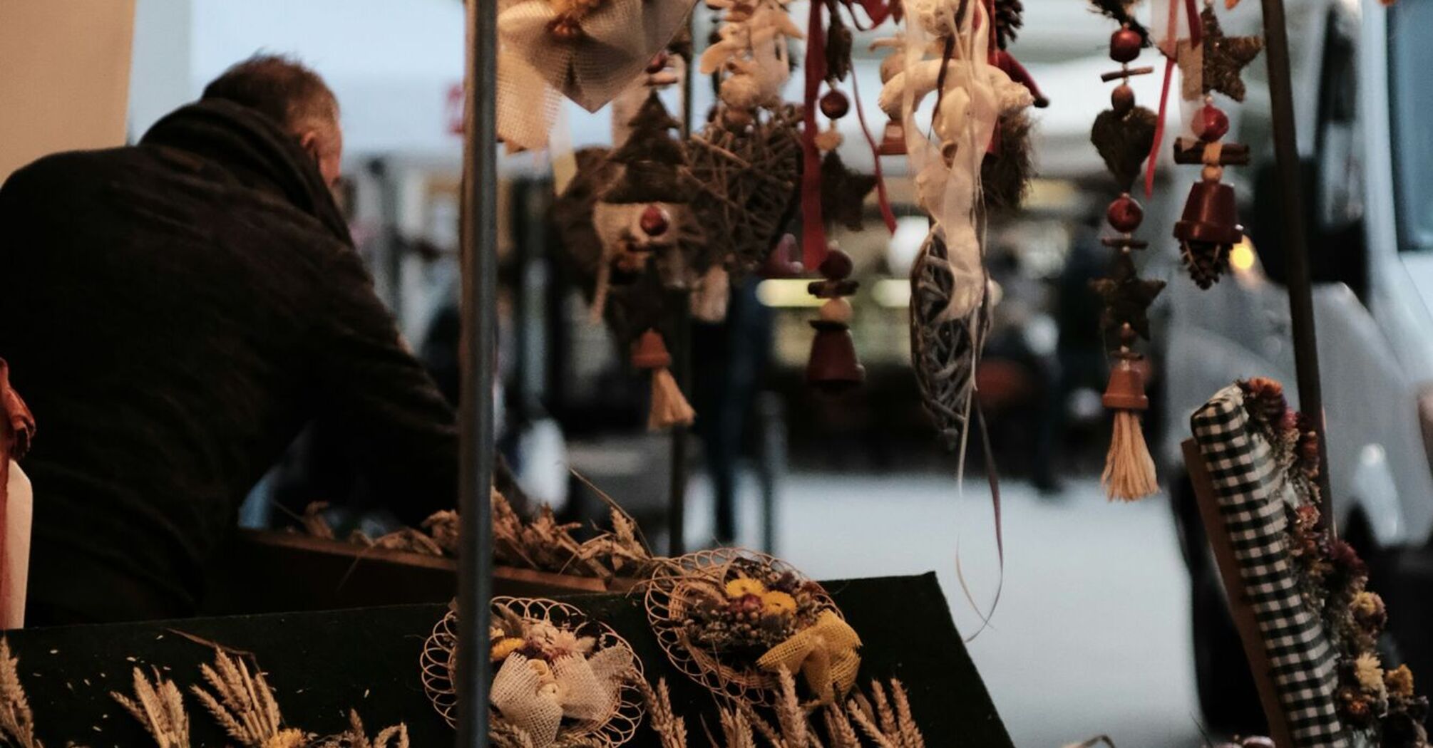 A vendor stall at the Weimar Onion Market displaying decorative onion garlands and dried floral arrangements under soft lights