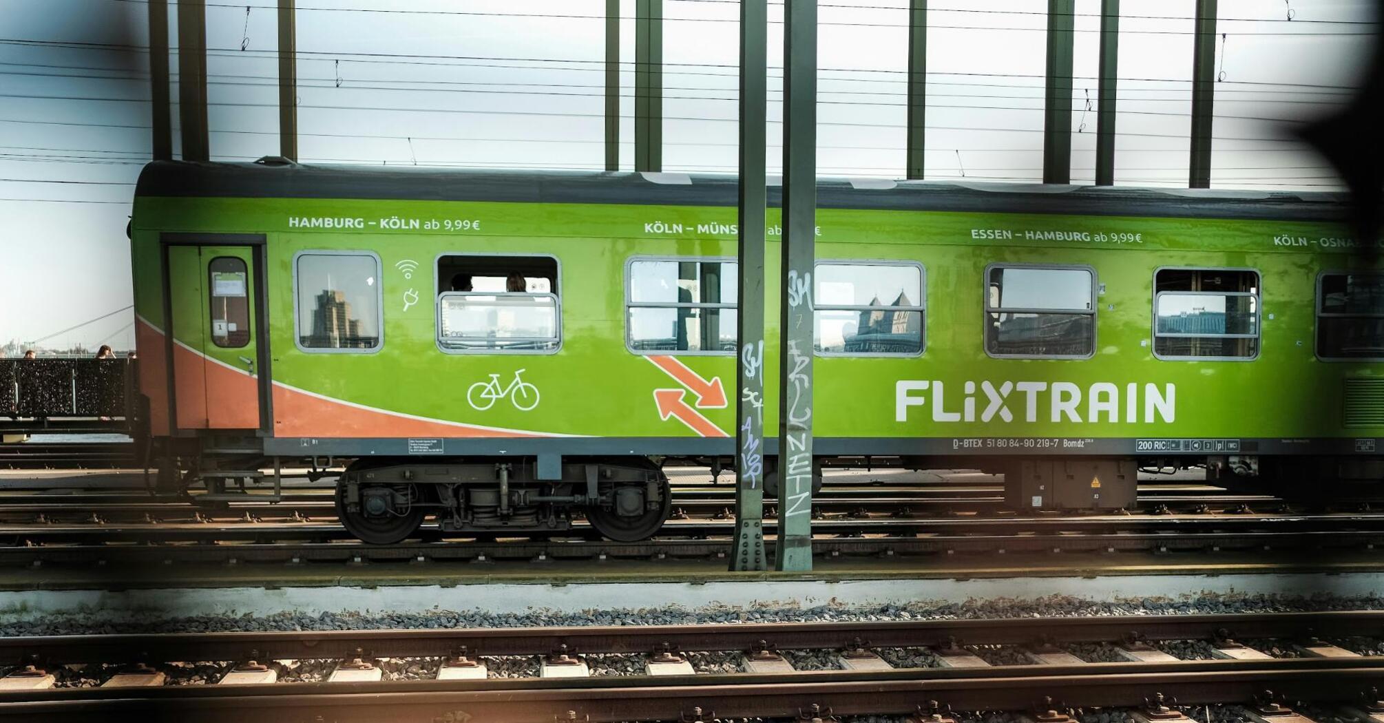 FlixTrain carriage parked at a station, advertising routes across Germany