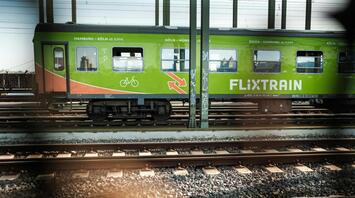 FlixTrain carriage parked at a station, advertising routes across Germany