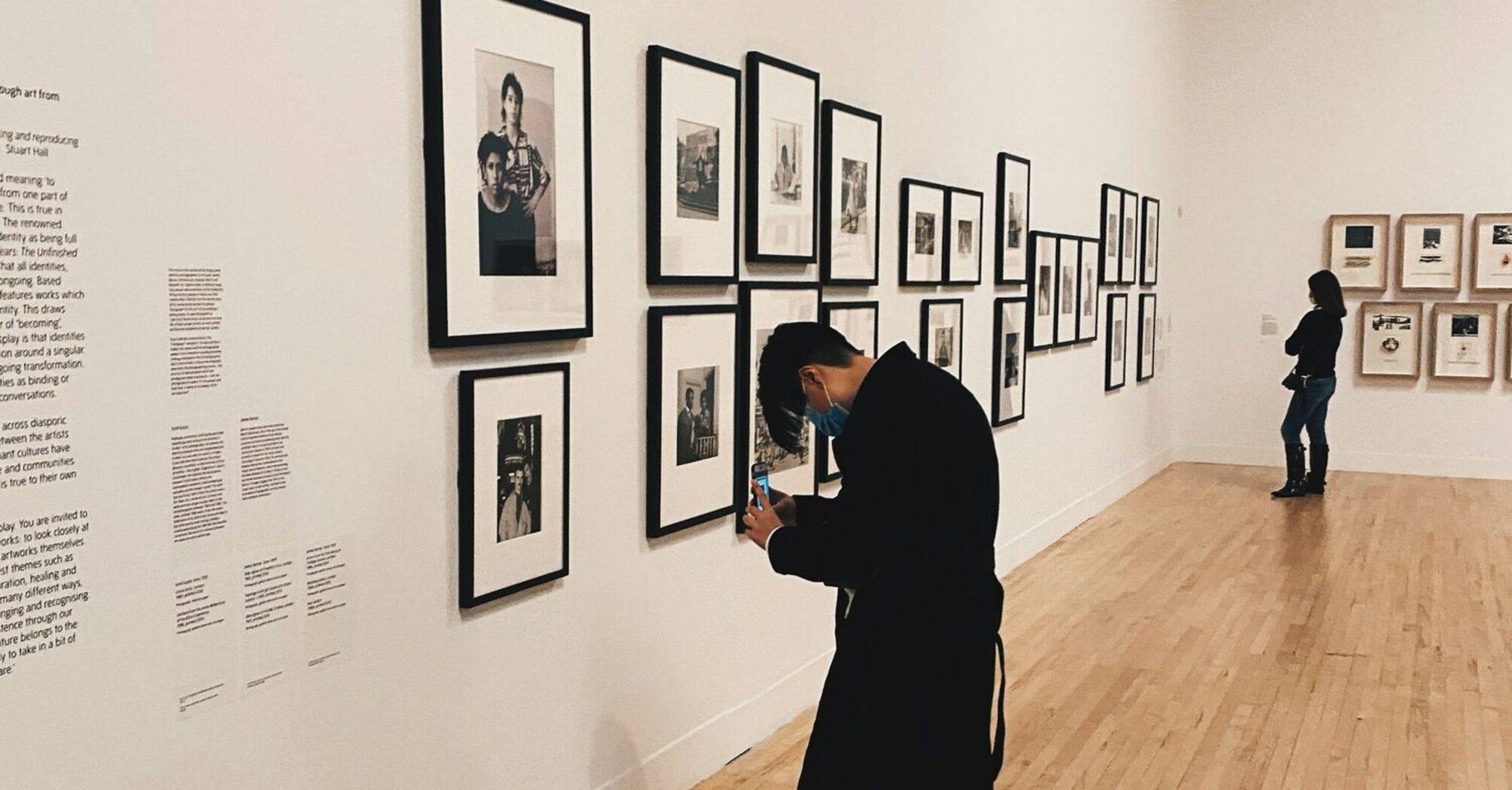 Visitor observing framed photographs in an art gallery