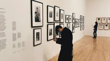 Visitor observing framed photographs in an art gallery