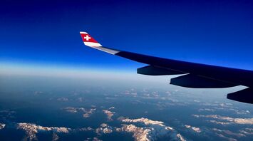 View of Swiss Alps from an airplane window with SWISS airline wing