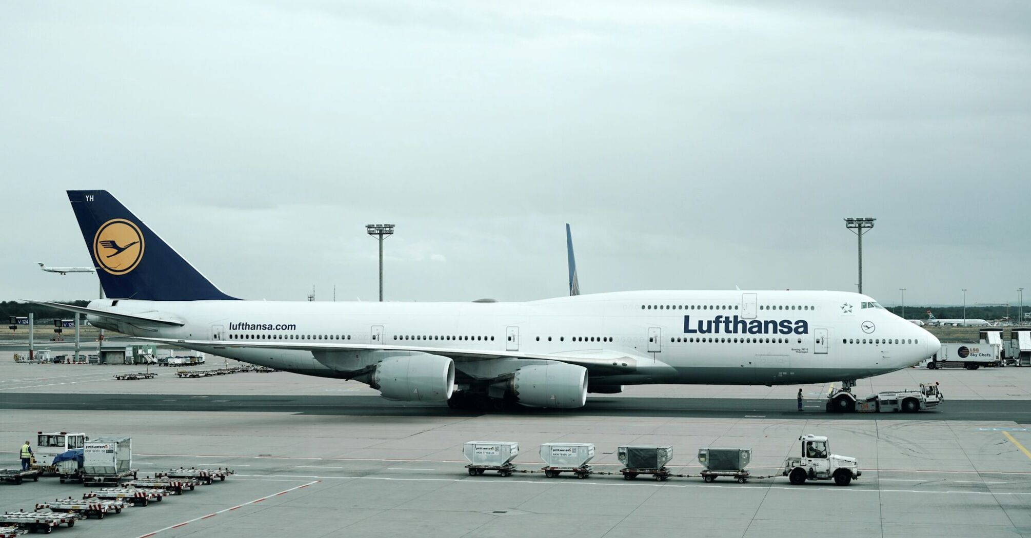 A Lufthansa aircraft at an airport gate, ready for departure