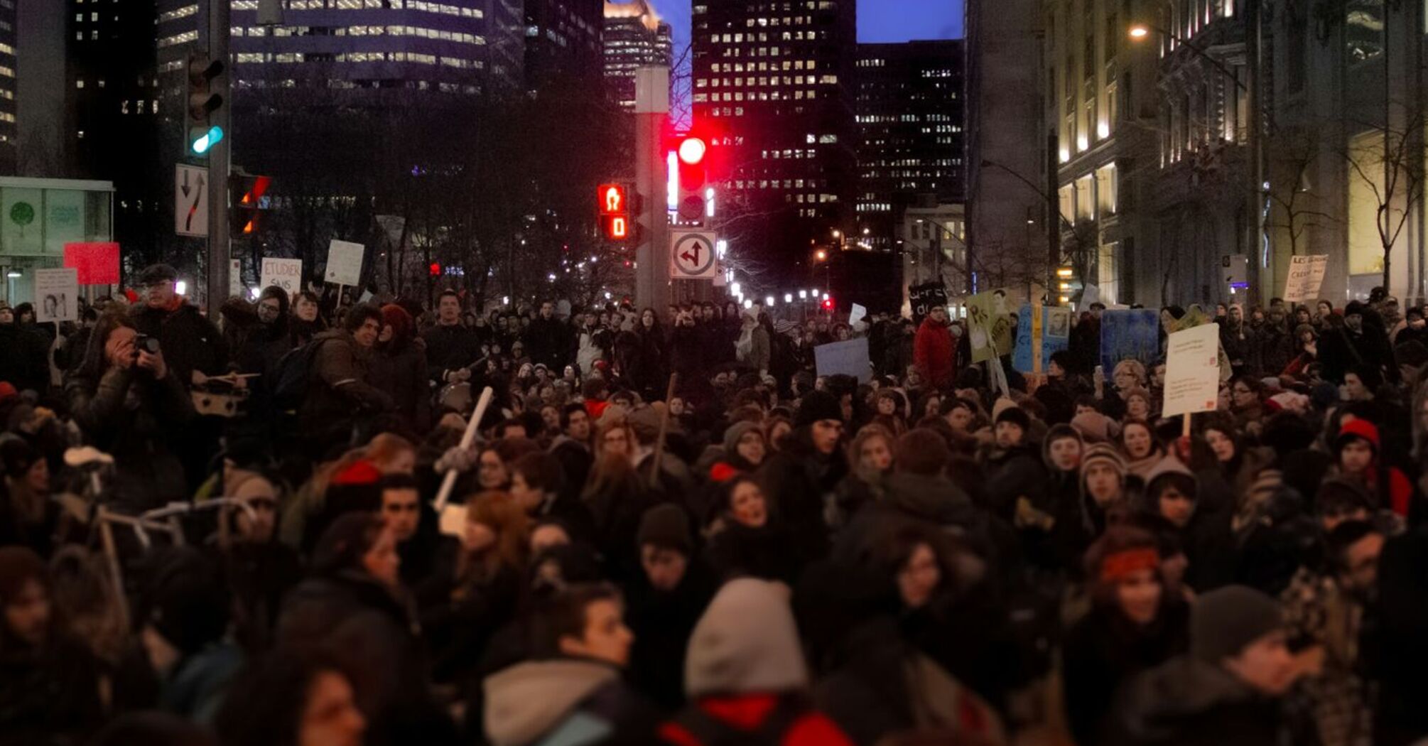 Large crowd protesting in a city at night