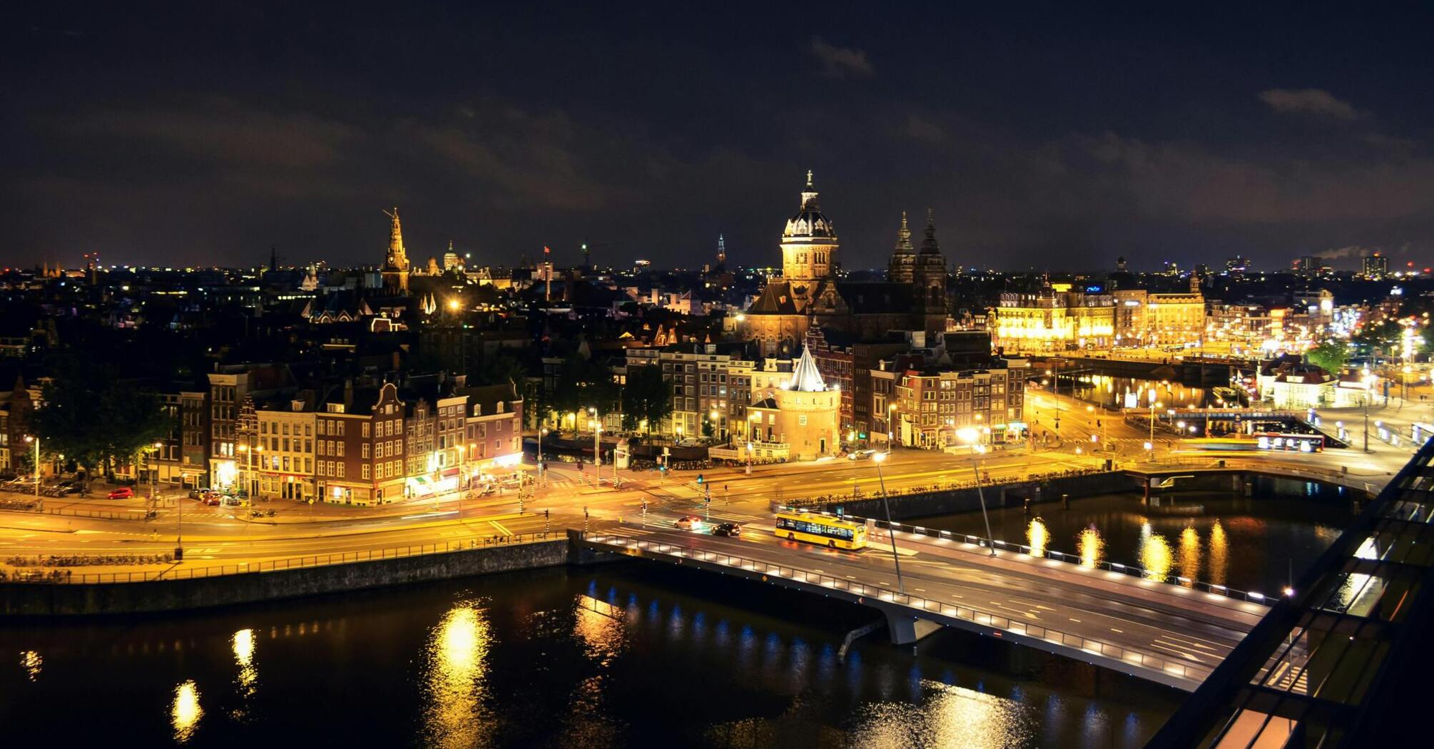 Night view of Amsterdam cityscape with illuminated buildings and streets