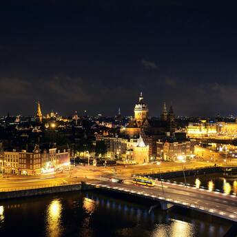 Night view of Amsterdam cityscape with illuminated buildings and streets