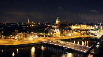 Night view of Amsterdam cityscape with illuminated buildings and streets