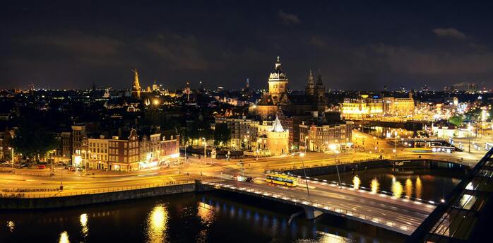 Night view of Amsterdam cityscape with illuminated buildings and streets