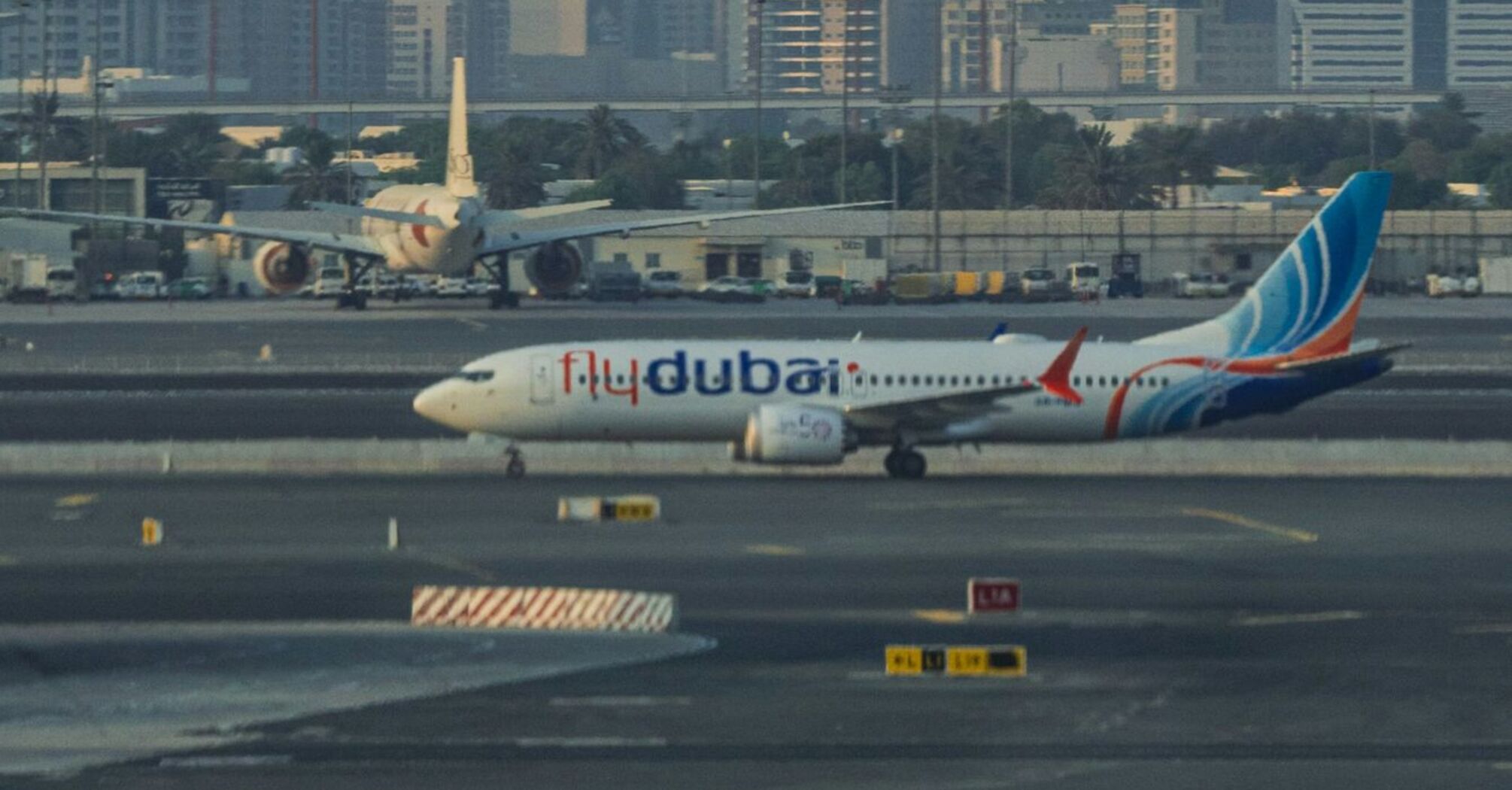 Flydubai aircraft on the runway with city skyline in the background