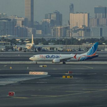 Flydubai aircraft on the runway with city skyline in the background