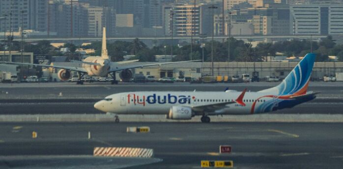 Flydubai aircraft on the runway with city skyline in the background
