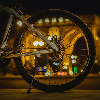 Bicycle wheel at night with city lights