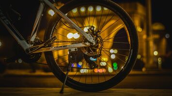 Bicycle wheel at night with city lights