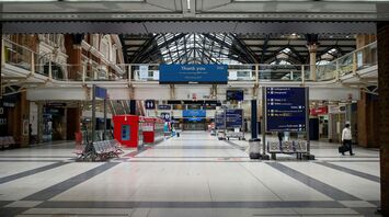 Empty concourse at Liverpool Street Station with directional signs and minimal foot traffic