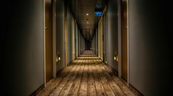 Dimly lit hotel corridor with wooden flooring