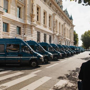 Row of police vans parked outside a historic building in Paris