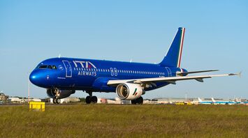 ITA Airways aircraft on runway with blue sky background
