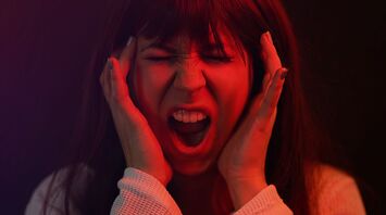 A woman screaming and holding her head in frustration