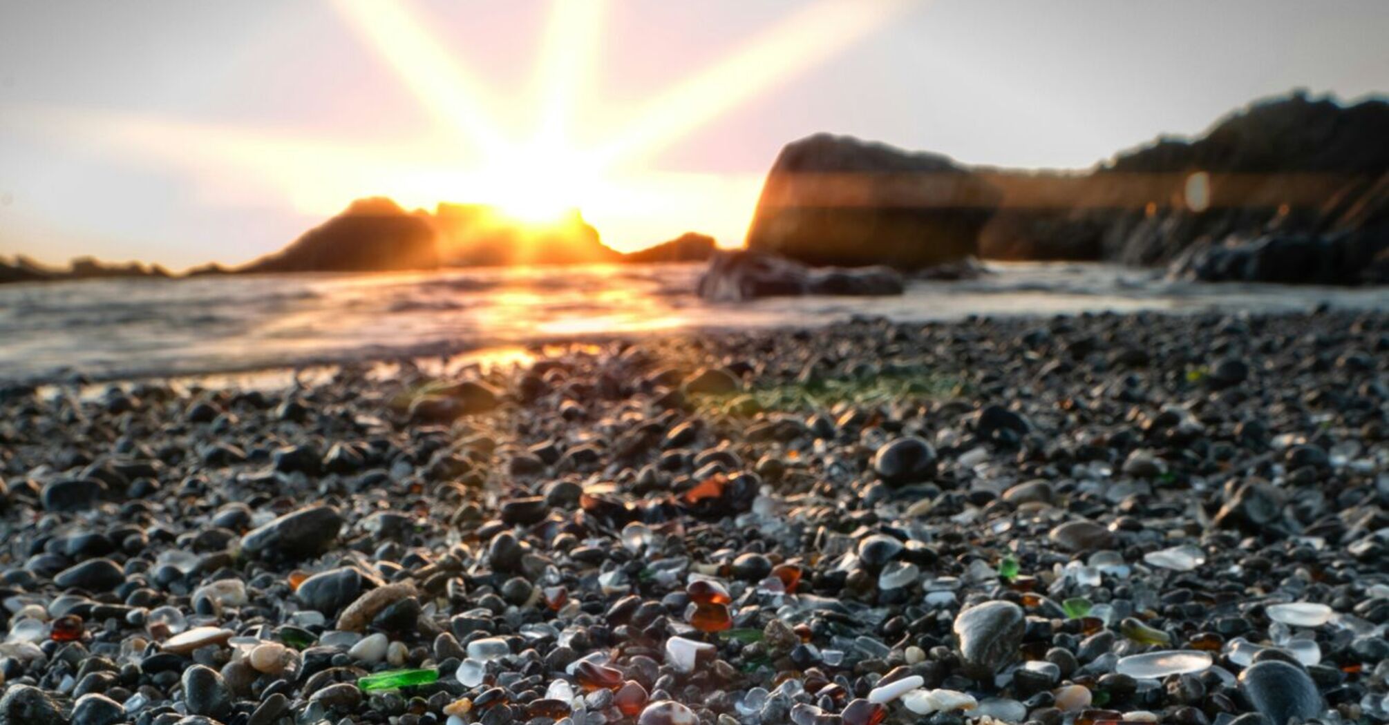 Colorful sea glass on the beach at sunset