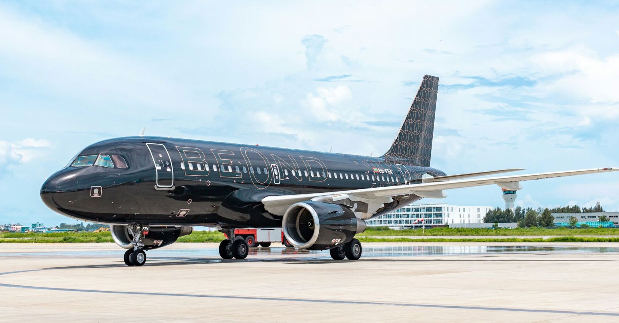 A sleek black beOnd airplane parked on the runway, showcasing its modern design and branding