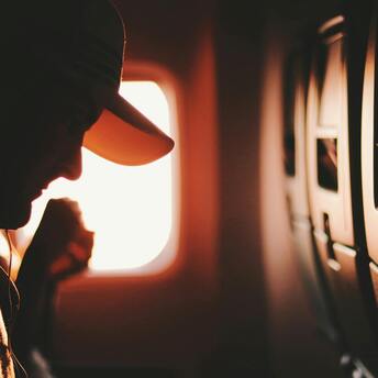 Close-up view of a passenger beside an airplane window