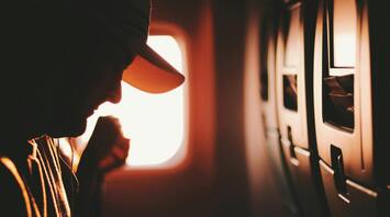 Close-up view of a passenger beside an airplane window