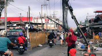 Damaged power lines and utility poles in a street affected by typhoon
