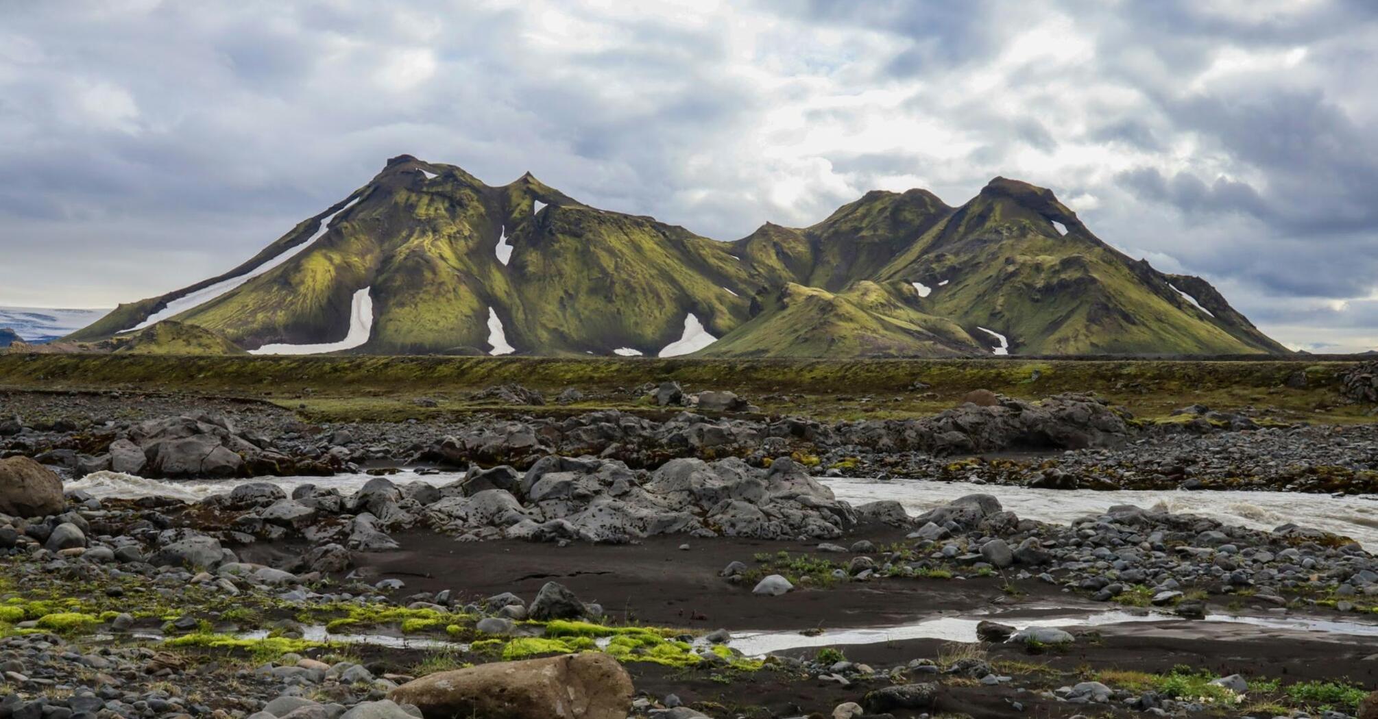 Majestic green mountains in Iceland's Highlands with patches of snow