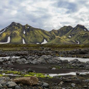 Majestic green mountains in Iceland's Highlands with patches of snow