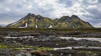 Majestic green mountains in Iceland's Highlands with patches of snow
