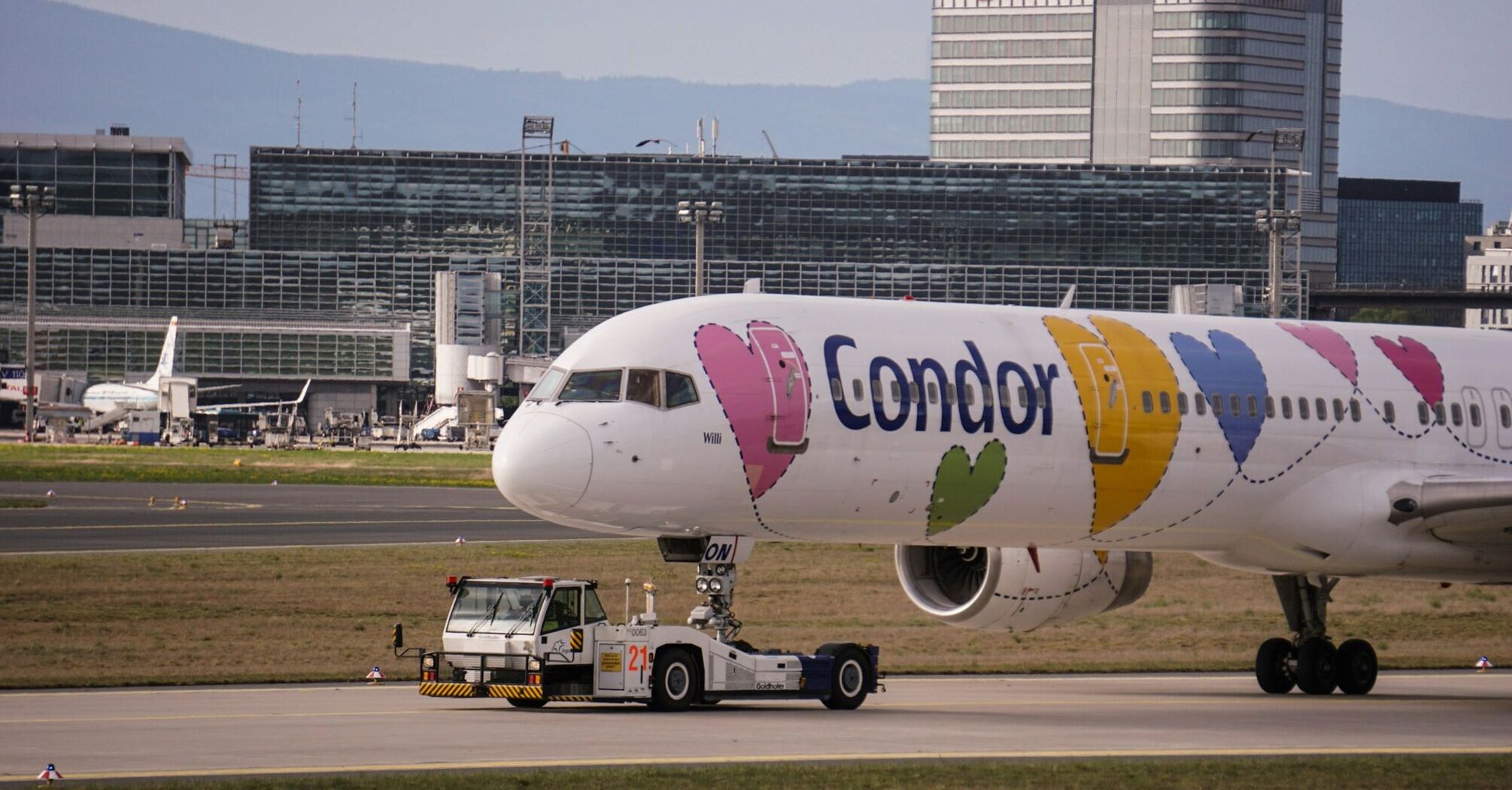 Condor Airlines plane with heart designs on the fuselage being towed at an airport