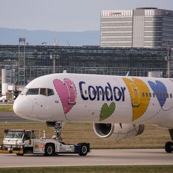 Condor Airlines plane with heart designs on the fuselage being towed at an airport