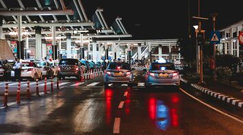 Cars waiting in line at a border control checkpoint at night