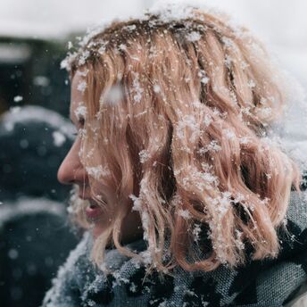 A woman with snow-covered hair in winter weather