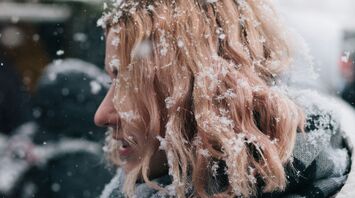 A woman with snow-covered hair in winter weather