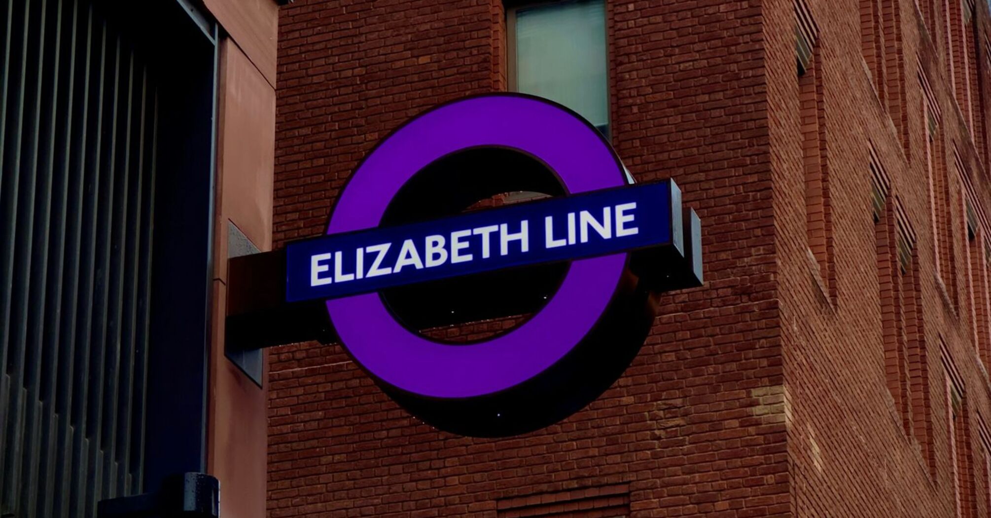 Elizabeth Line station sign on a brick building in London