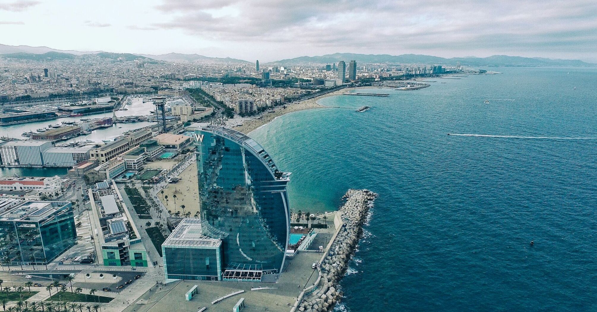 Aerial view of Barcelona's coastline with the prominent W Hotel near the beach, overlooking the Mediterranean Sea