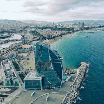 Aerial view of Barcelona's coastline with the prominent W Hotel near the beach, overlooking the Mediterranean Sea