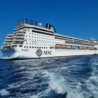 MSC cruise ship sailing in open water under a clear blue sky