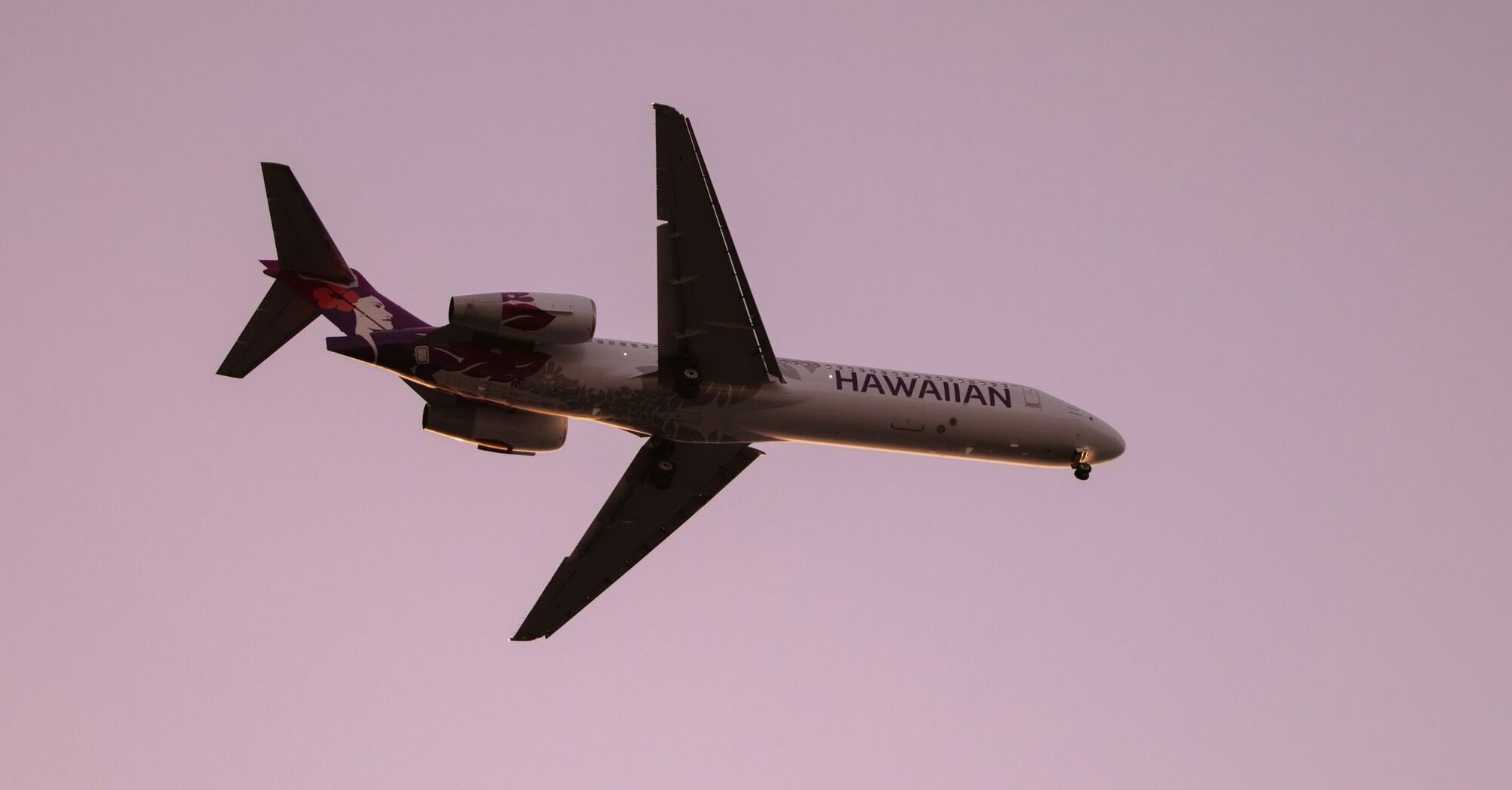 Hawaiian Airlines plane in flight at sunset