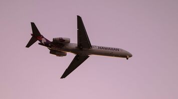 Hawaiian Airlines plane in flight at sunset