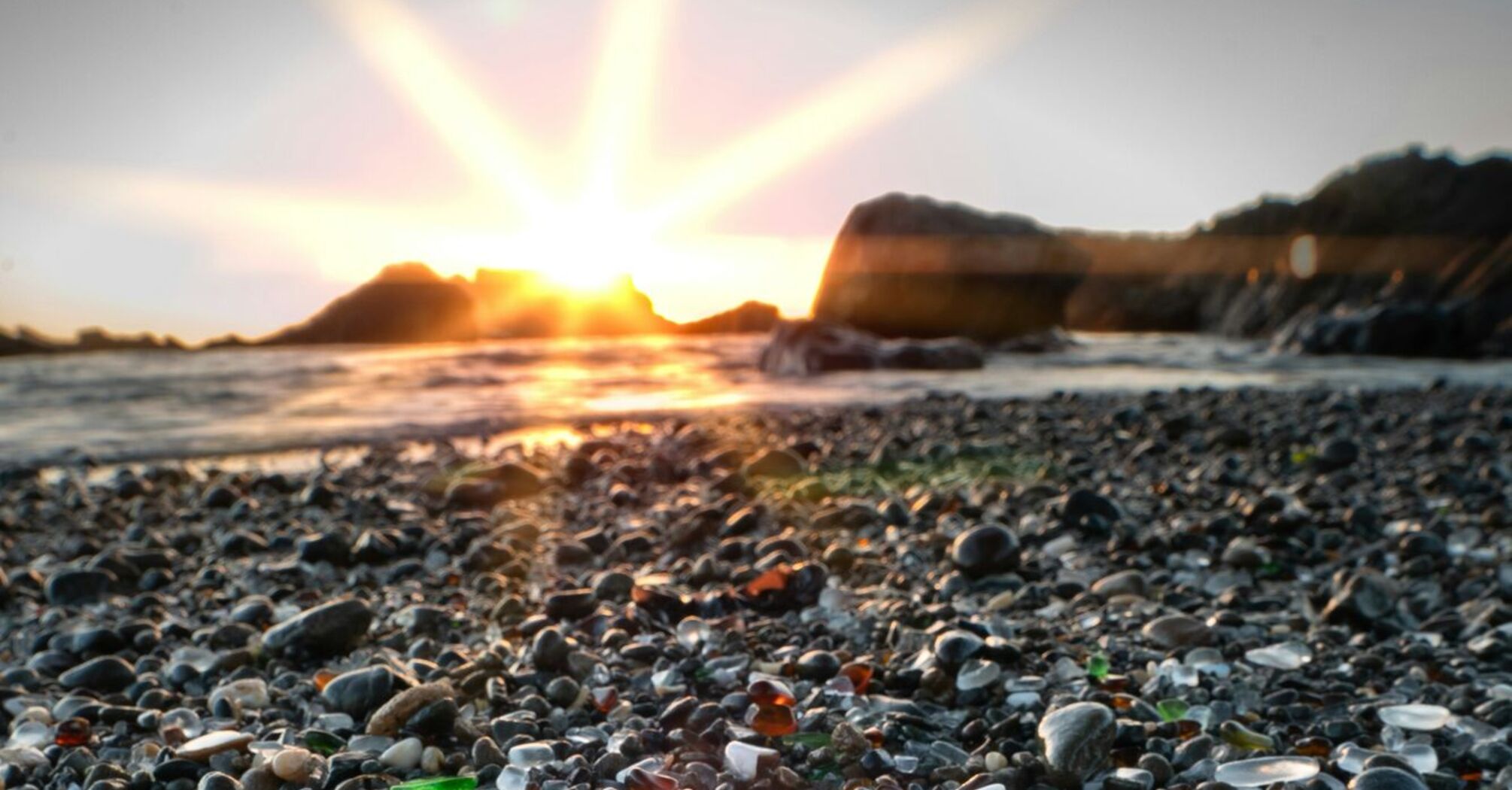 Colorful sea glass on the beach at sunset