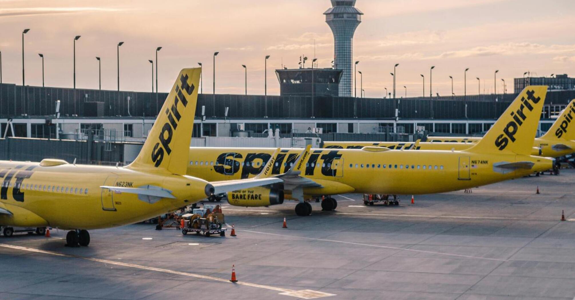 Spirit Airlines airplanes parked at the airport terminal during sunset